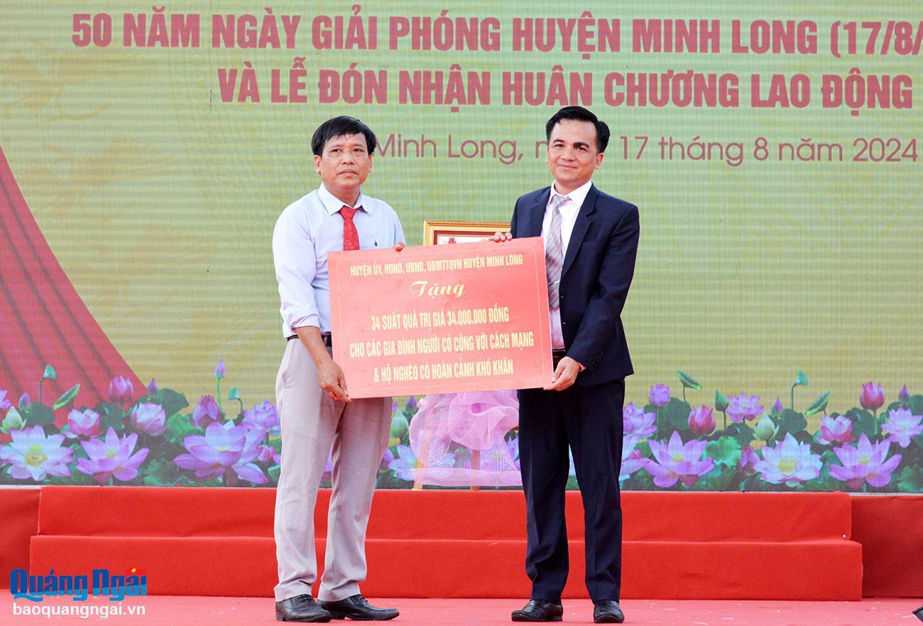 Lãnh đạo huyện Minh Long trao bản tượng trưng tặng 34 triệu đồng cho các hộ nghèo, gia đình có công với cách mạng trên địa bàn huyện.